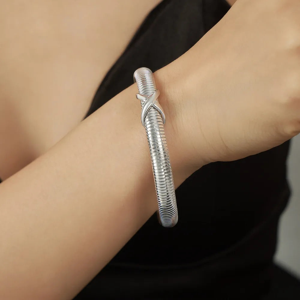 Silver spring coil bracelet with twisted knot clasp on wrist