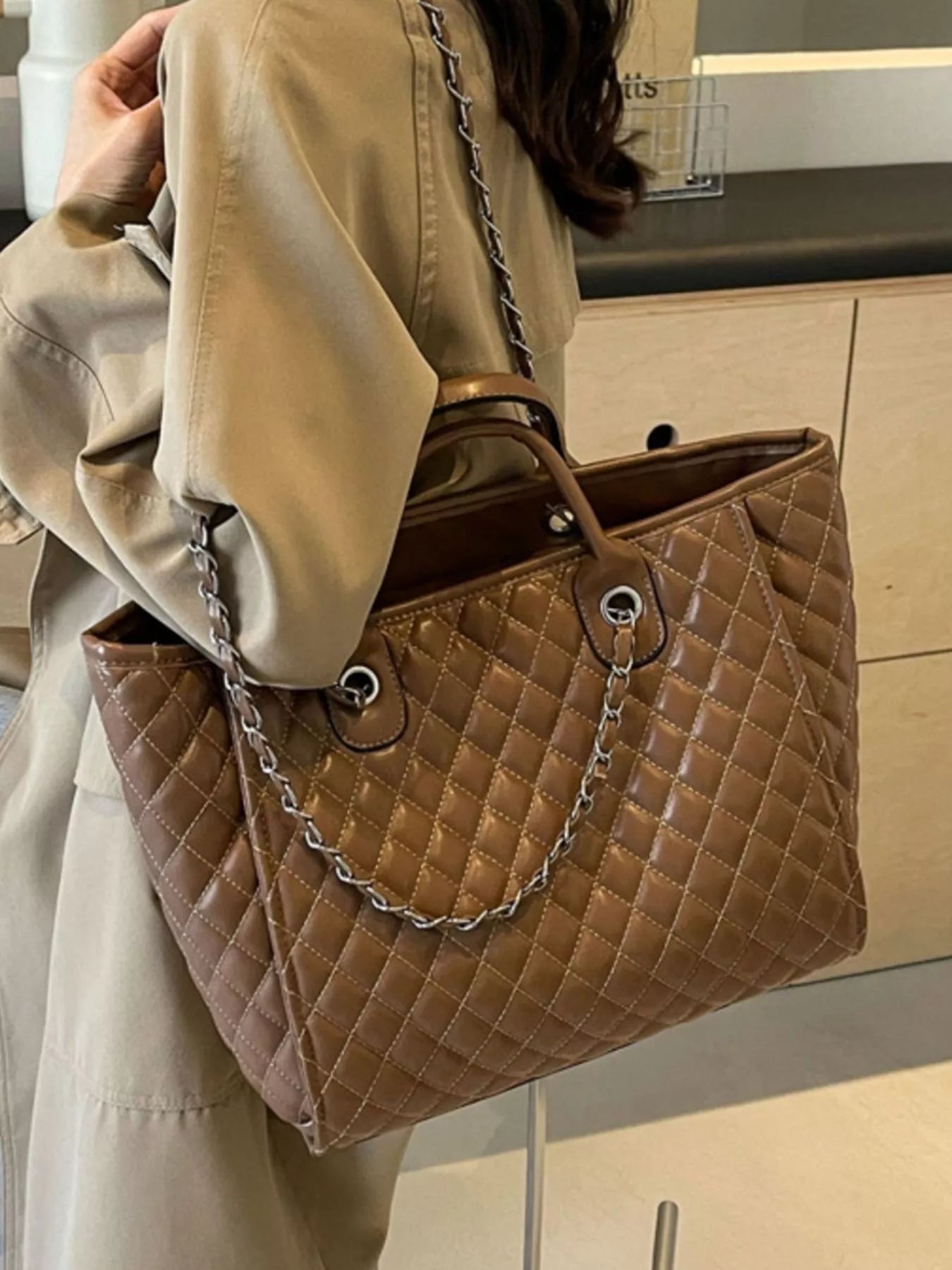 Brown quilted medium vegan leather bag with chain shoulder strap and metal eyelet accents