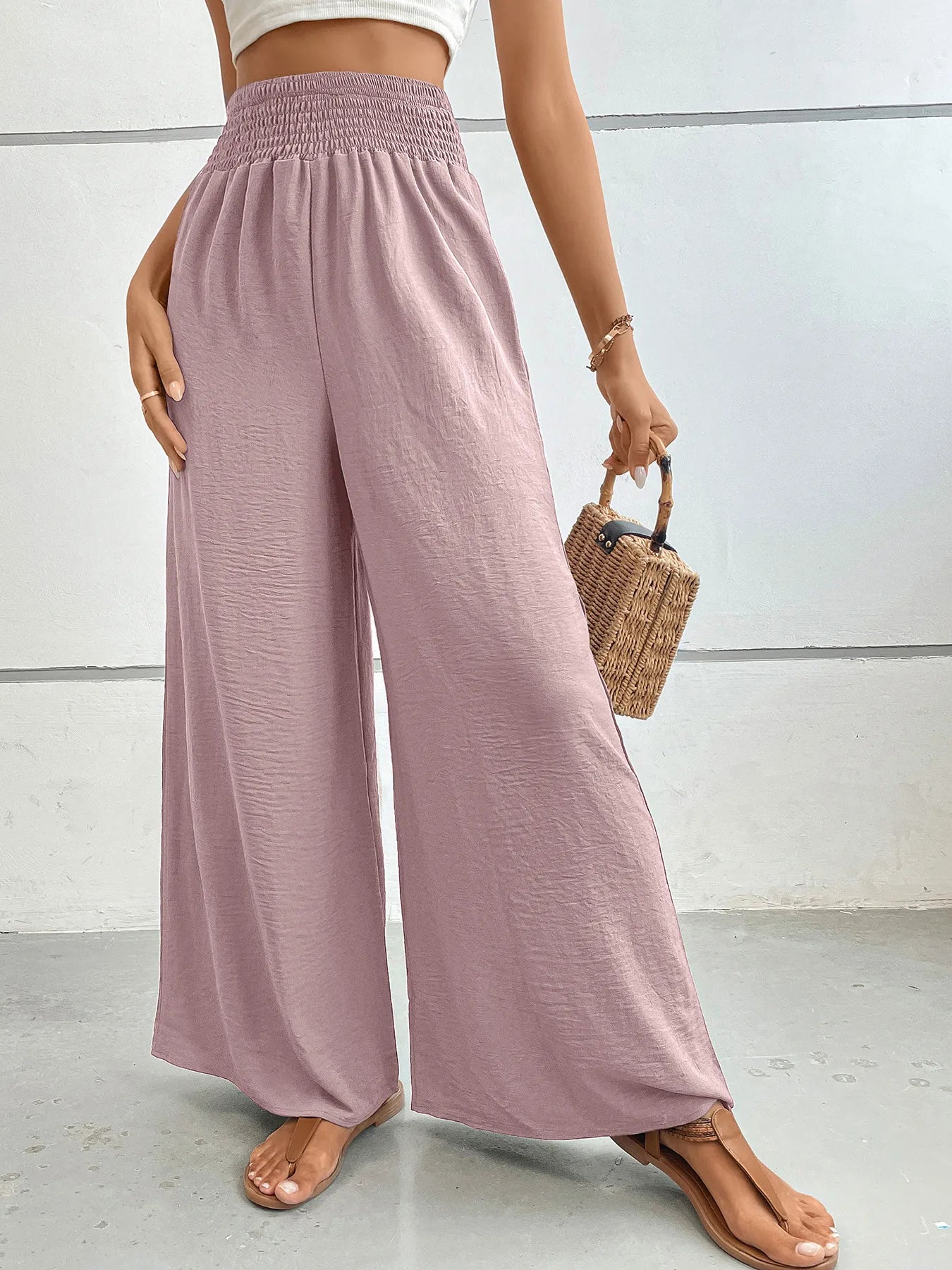 High-waisted wide-leg pants in dusty pink with smocked elastic waist and full-length flare