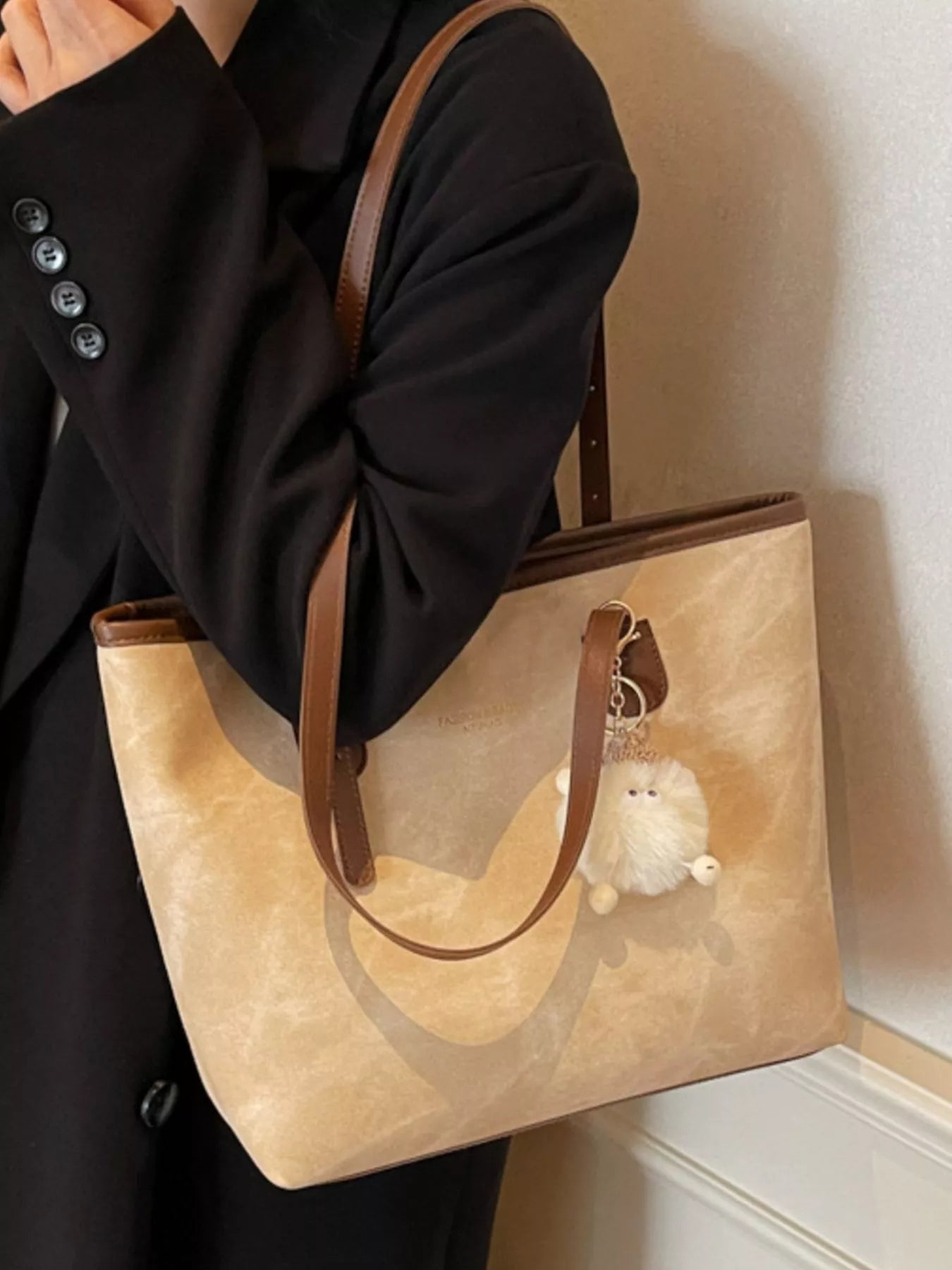 Shoulder bag in tan PU leather, medium size, with brown straps and fluffy white plush charm.