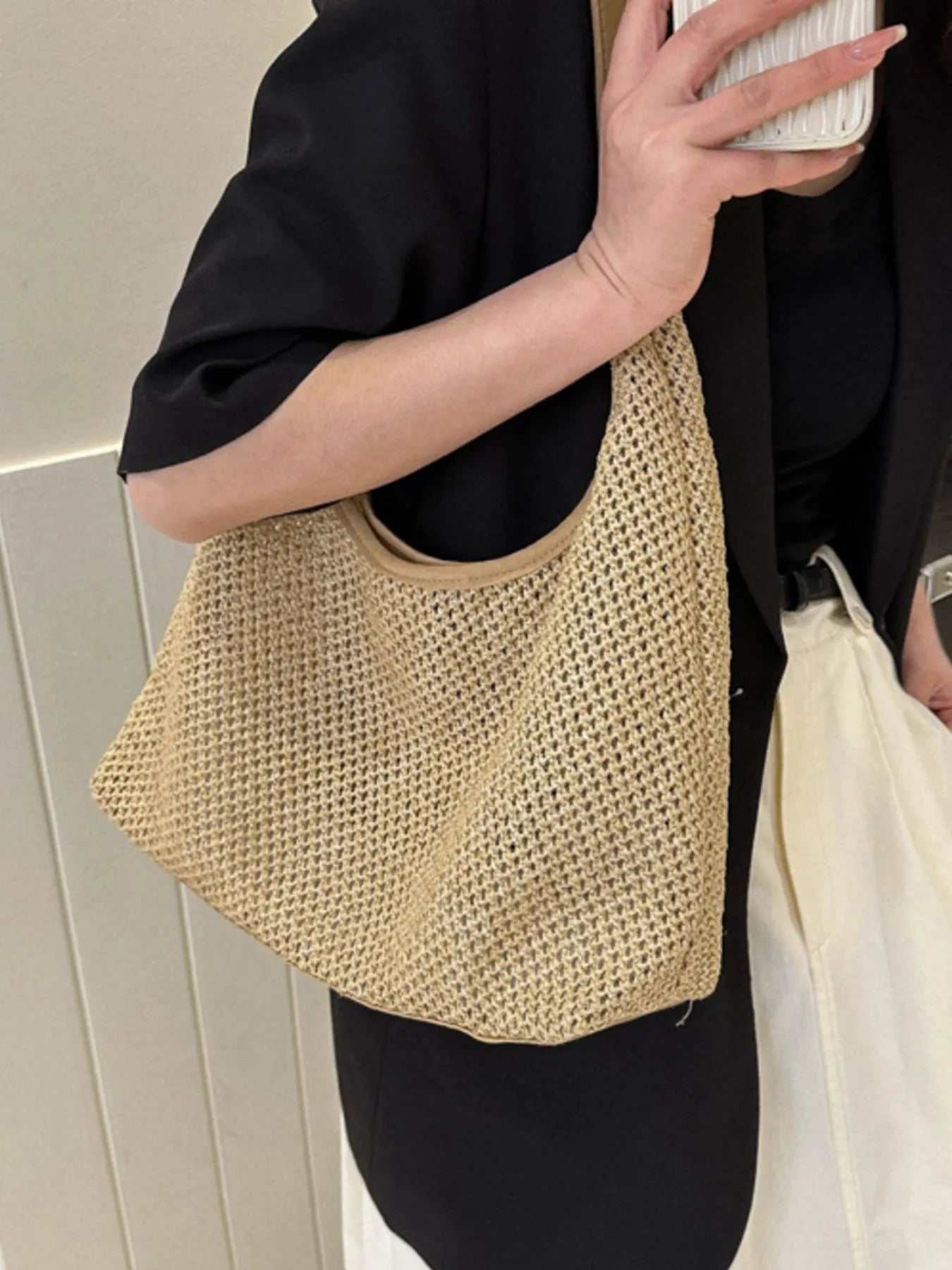 Woven straw shoulder bag in tan with cream handles and curved open top