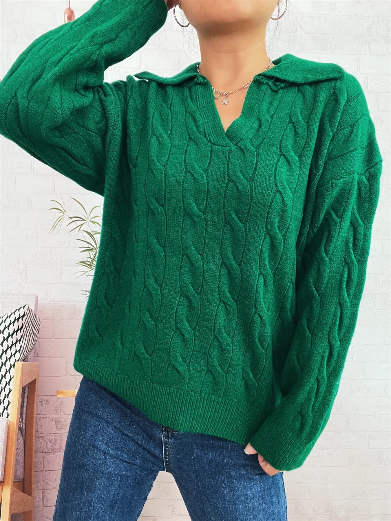Green cable-knit johnny-collar sweater with long sleeves, textured cable front.