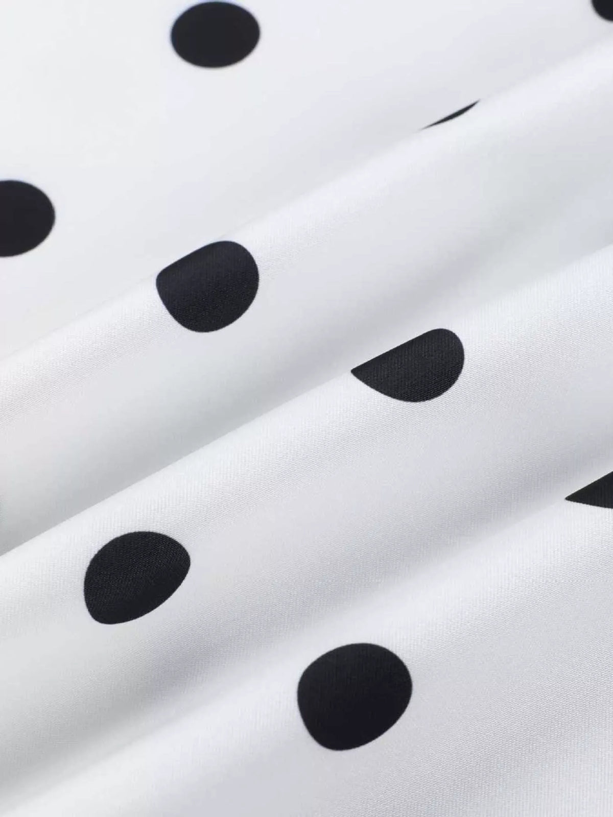 White fabric with black polka dots, soft knit texture