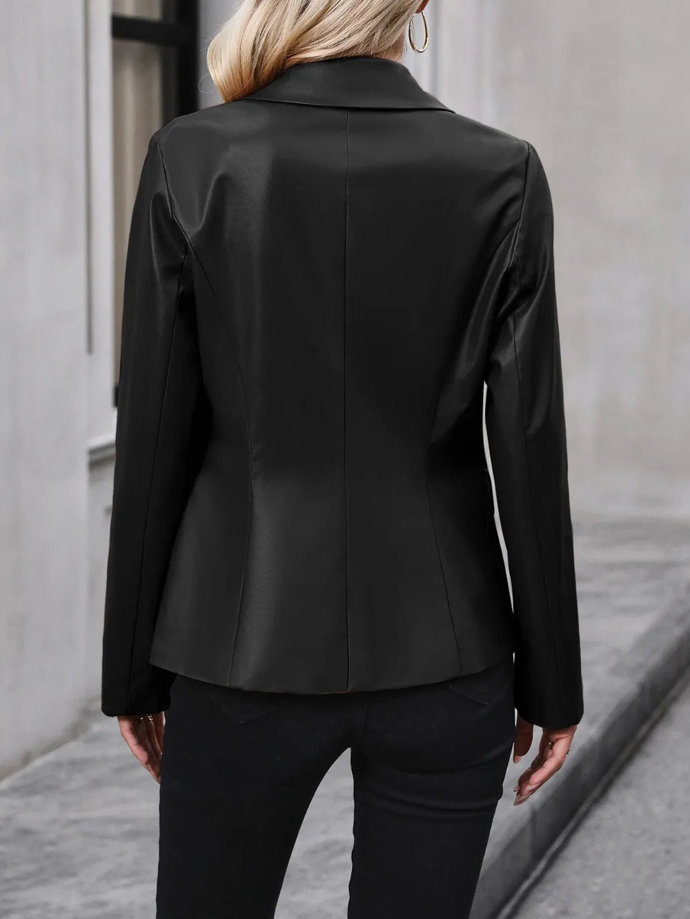 Women’s black blazer back view with long sleeves and center seam detail