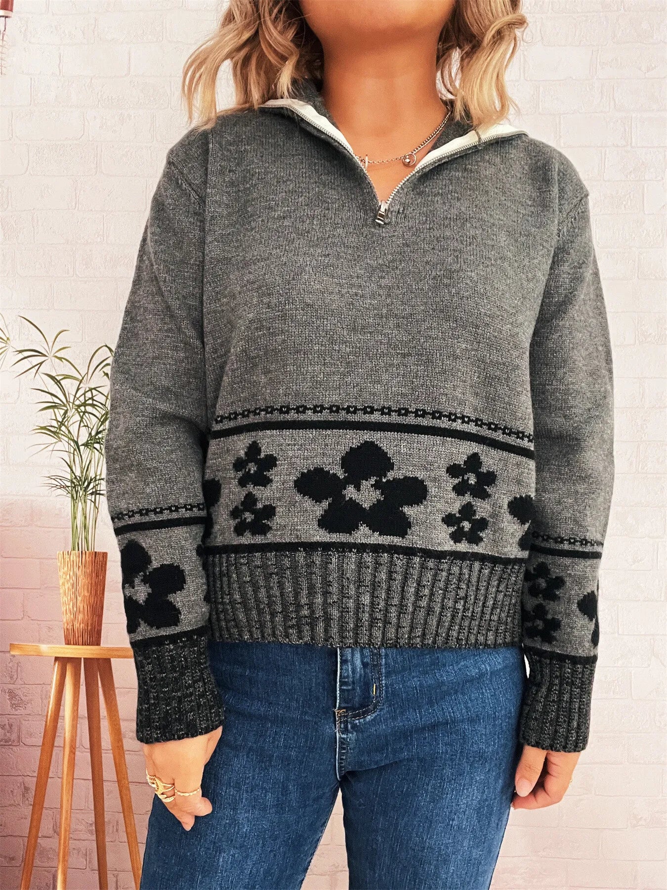 Gray long-sleeve half-zip sweater with black floral stripe across the midsection