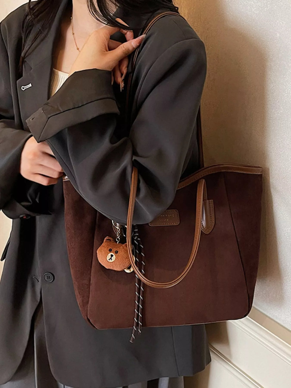 Brown suede tote bag with two handles and front pocket, bear charm with tassel