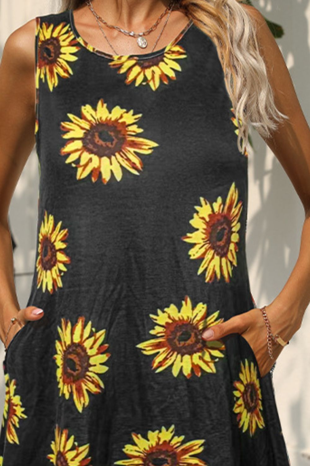 Black sleeveless dress with yellow sunflower print and round neckline