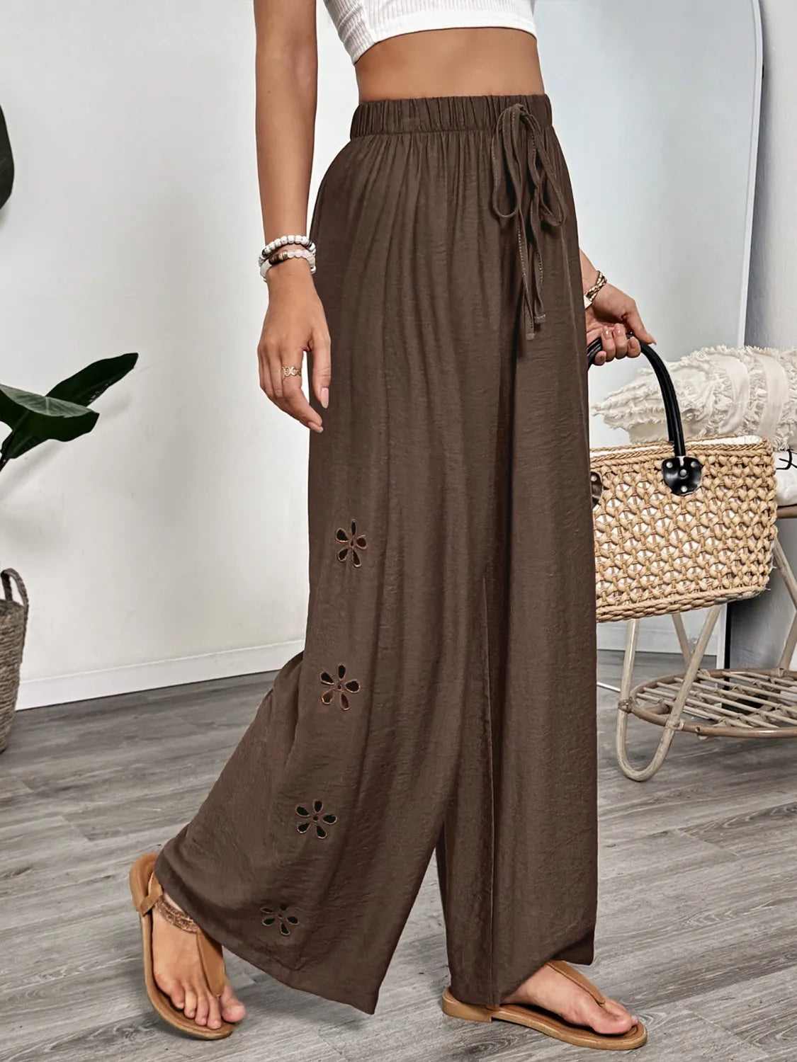 Dark brown wide-leg pants with tie waist and embroidered floral cutouts