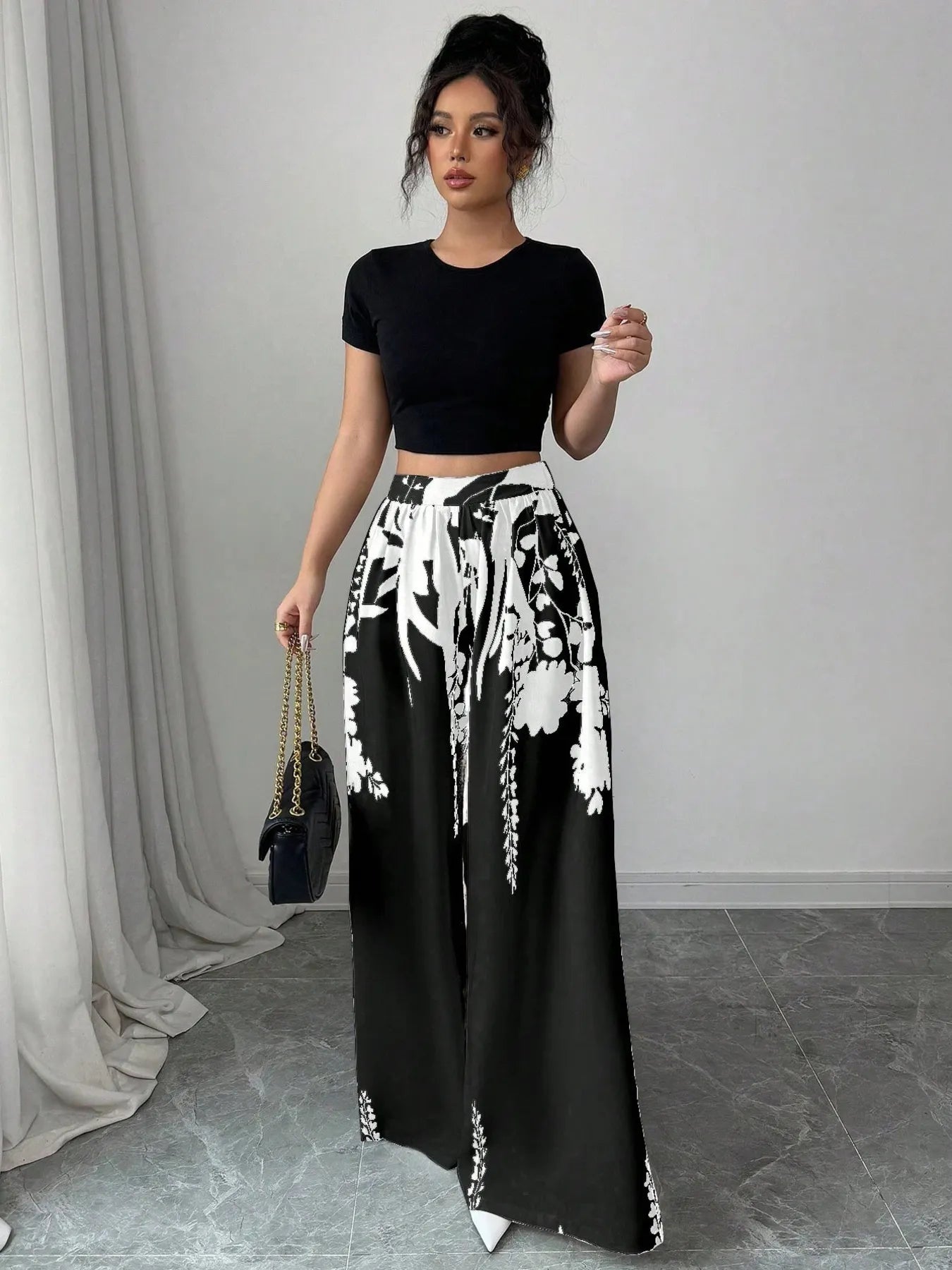 Black and white printed wide-leg pants with elastic waist and drawstring, floral motif