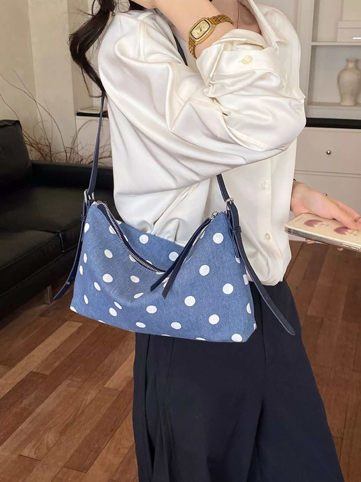 Blue polka dot small shoulder bag with zipper closure and dangling strap ends