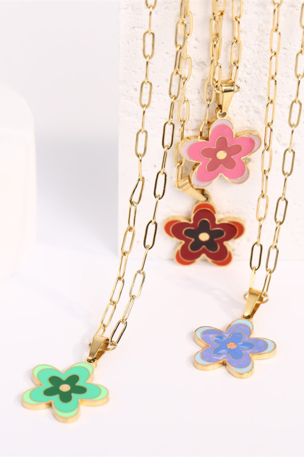 Layered gold-tone flower pendant necklace with pink, red, blue, and green charms
