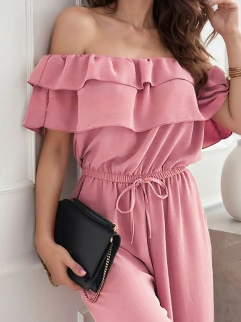 Dusty pink off-shoulder ruffled jumpsuit with tiered neckline and tie waist detail