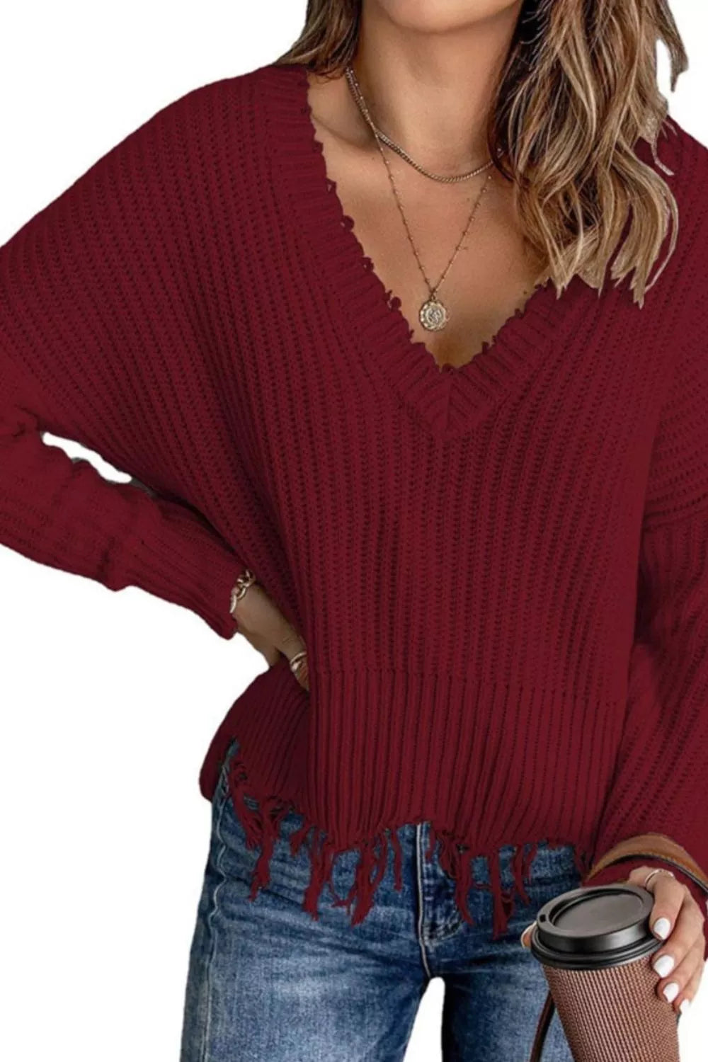 Burgundy V-neck knit sweater with ribbed cuffs and raw fringe hem