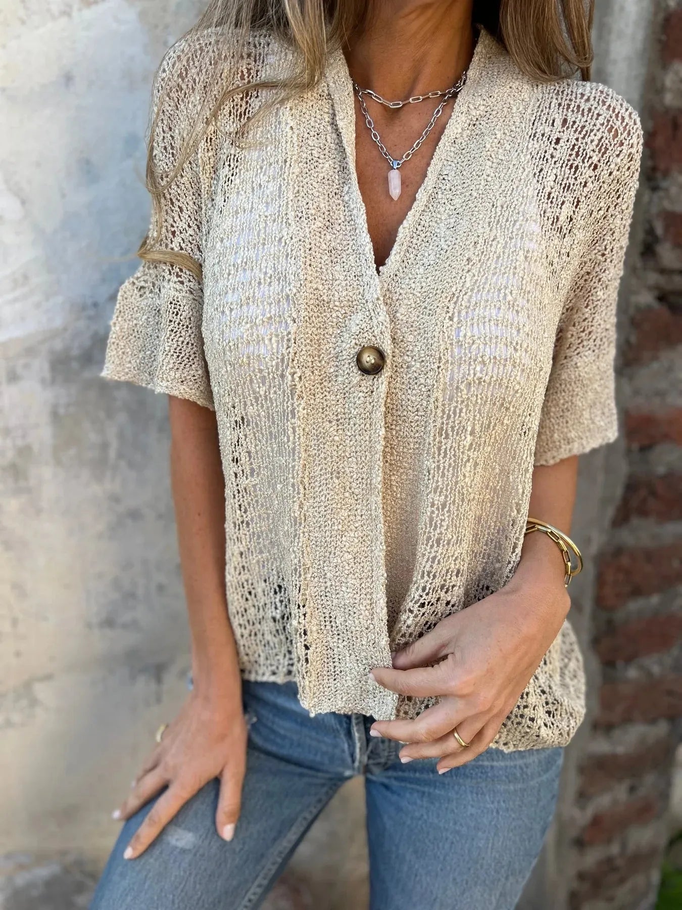V-neck openwork cardigan with one button, short sleeves, and relaxed fit in cream tone.