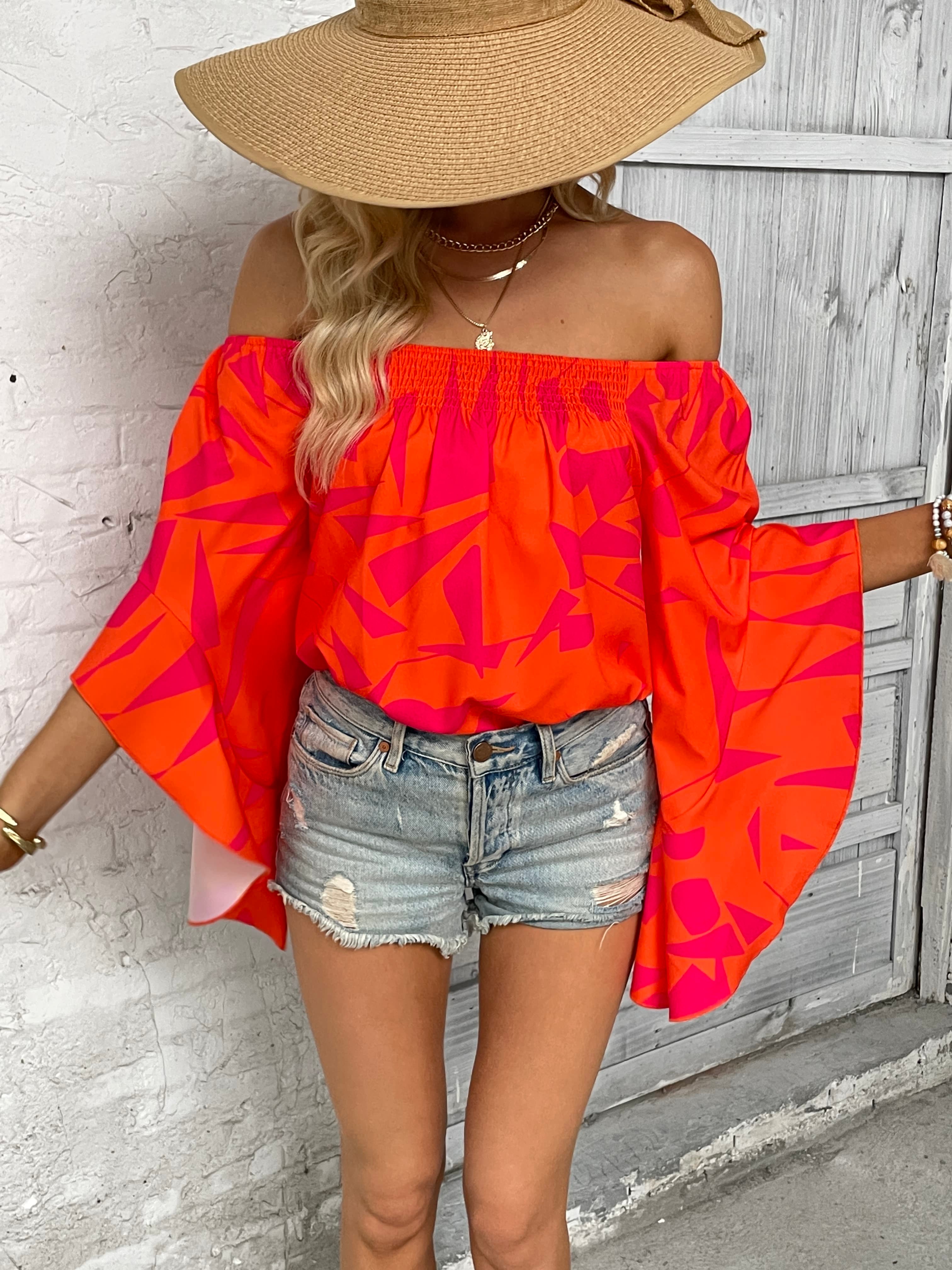 Off-shoulder bell sleeve blouse in bright orange with red abstract print