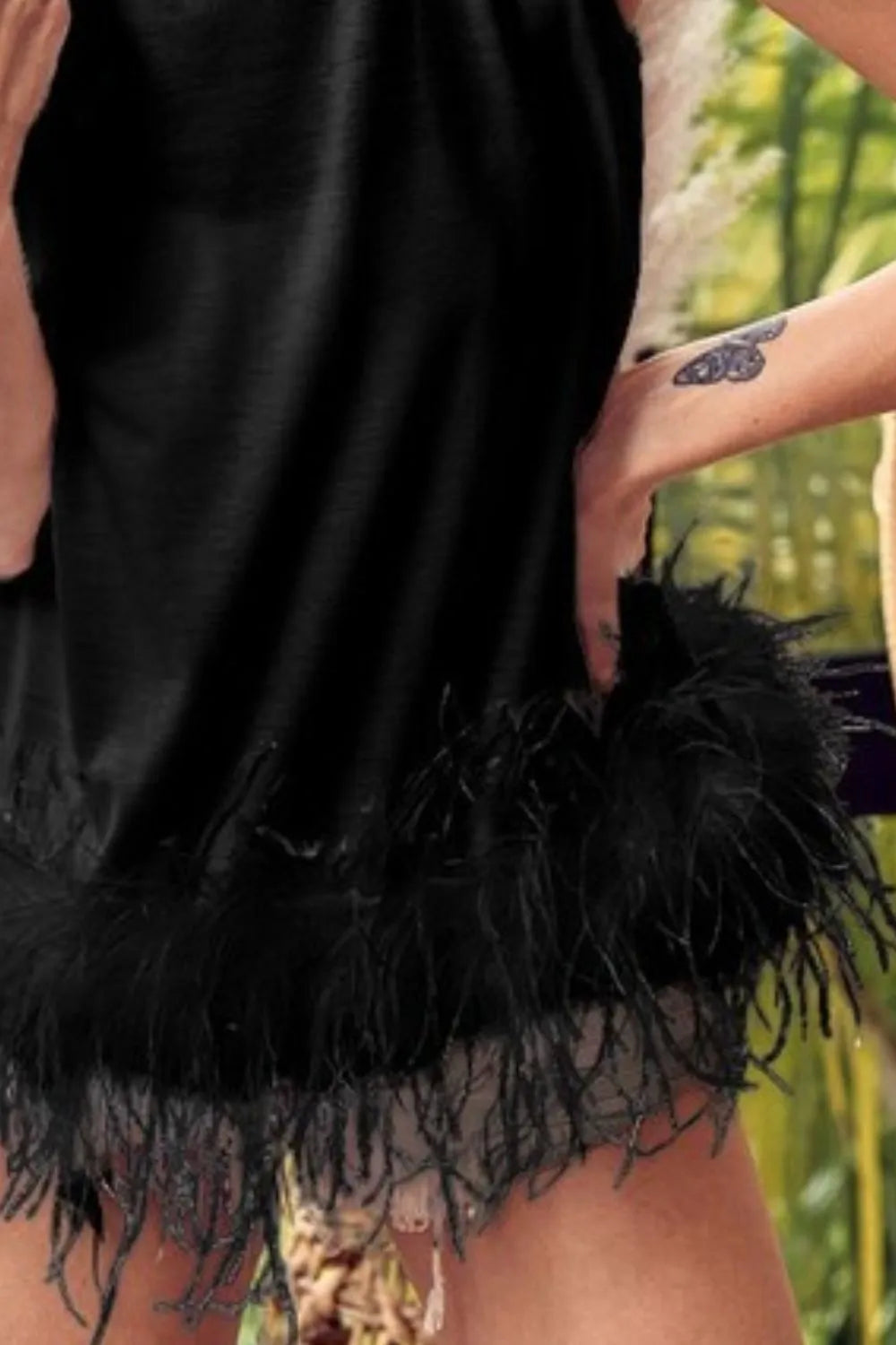 Black sleeveless top with layered faux feather fringe hem