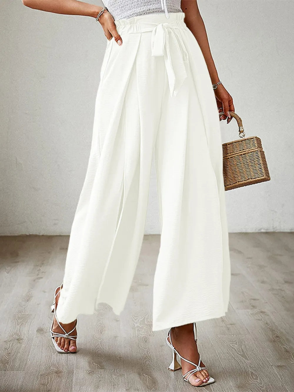 White tied-waist wide-leg pants with front ribbon tie and pleated wide legs