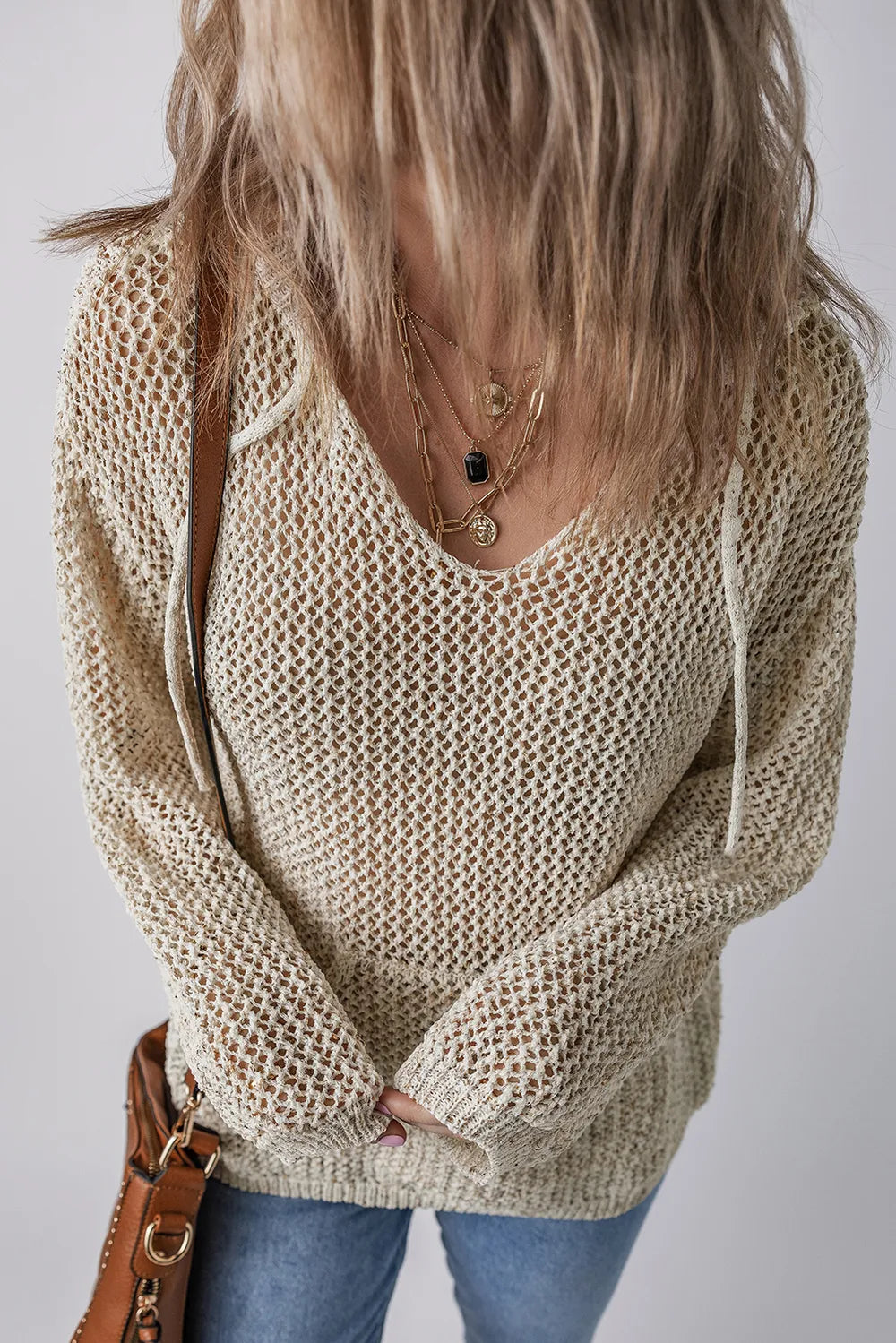 Beige openwork knit hooded top with V-neck, dropped shoulders, and front pocket