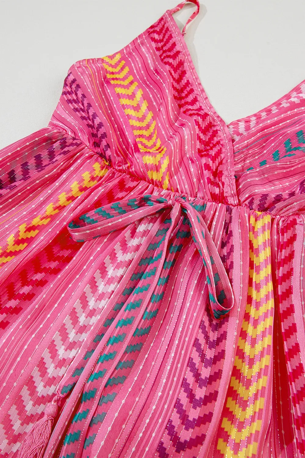 Close-up of pink printed cami dress bodice with bow tie and zigzag pattern