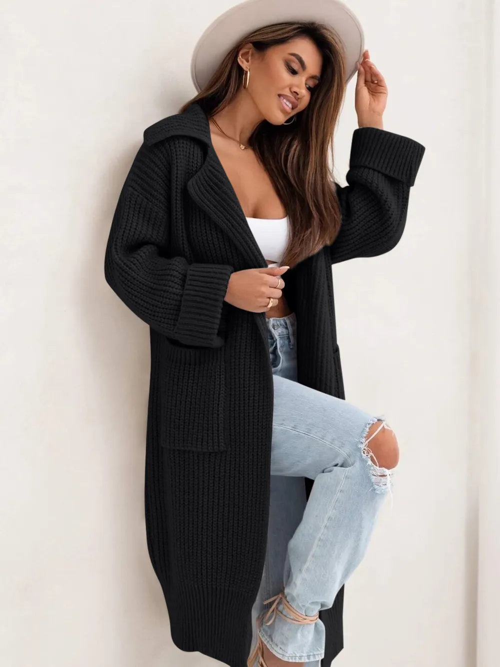 Black long knit cardigan with collared neck, dropped shoulders, and side pockets