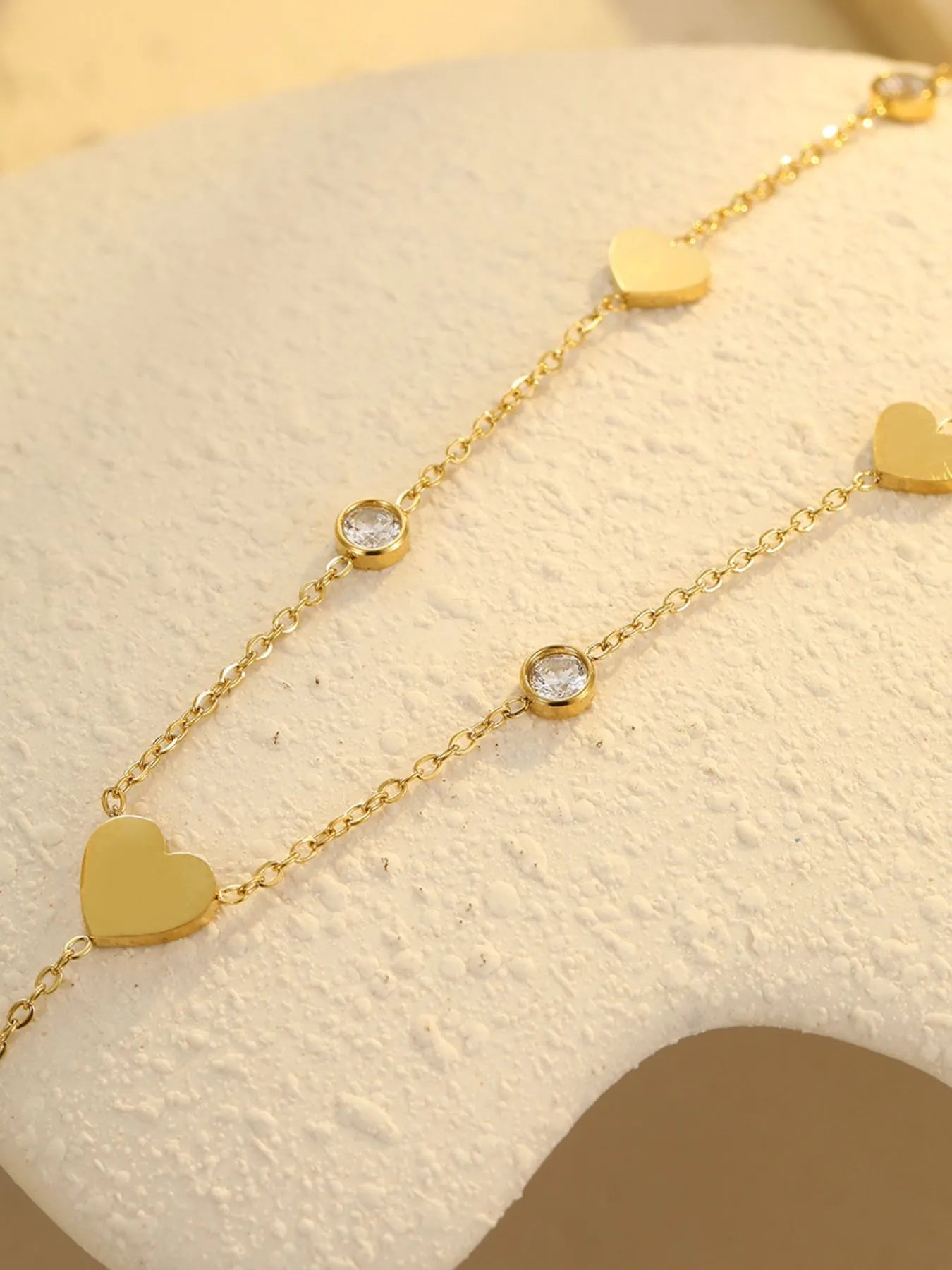 Gold heart zircon station necklace with heart charms and round clear stones