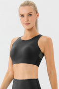 Black active bra with round neckline and wide straps, cropped front view