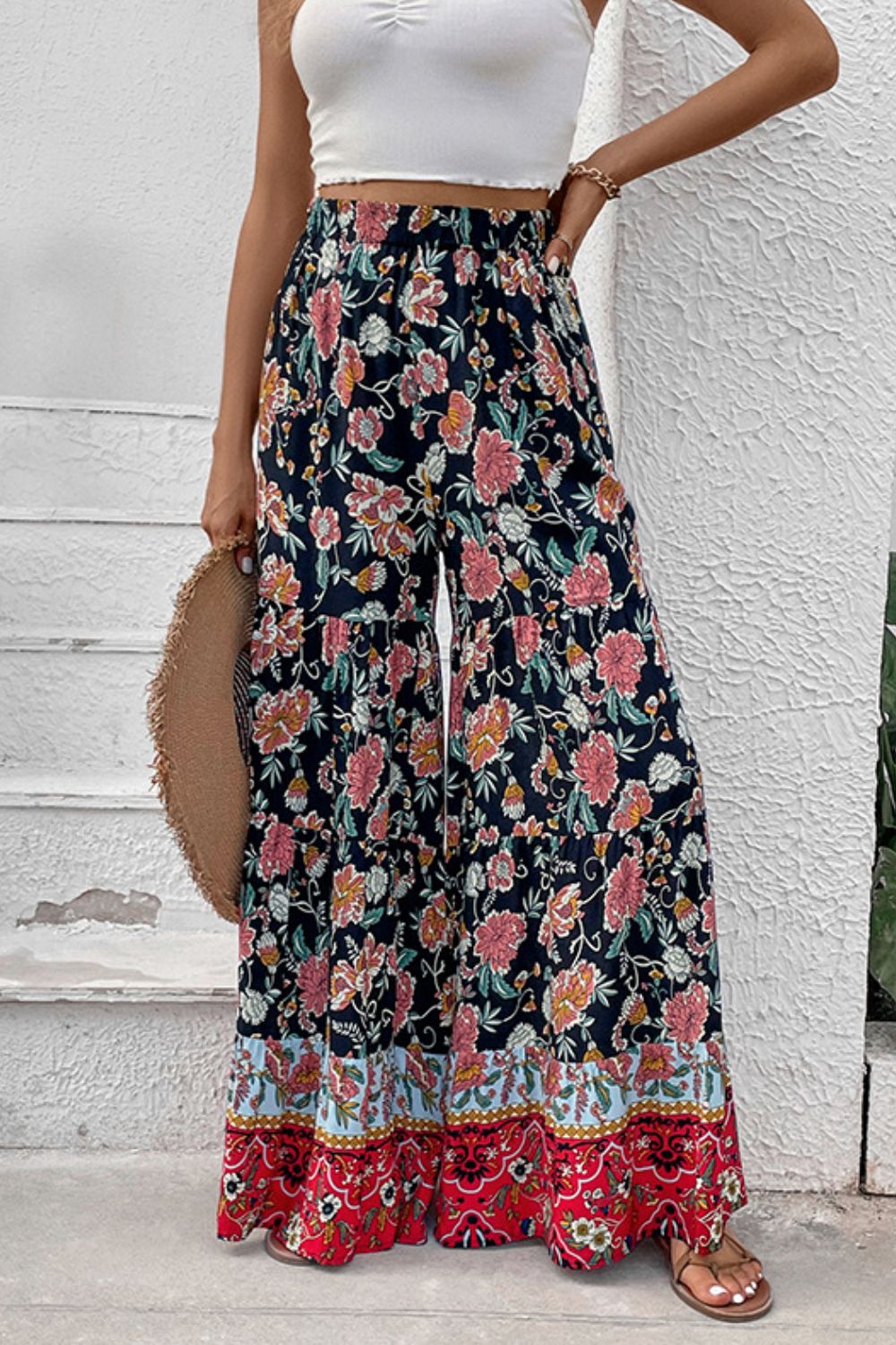 Floral high-waist palazzo pants with dark background, pink flowers, and red hem trim