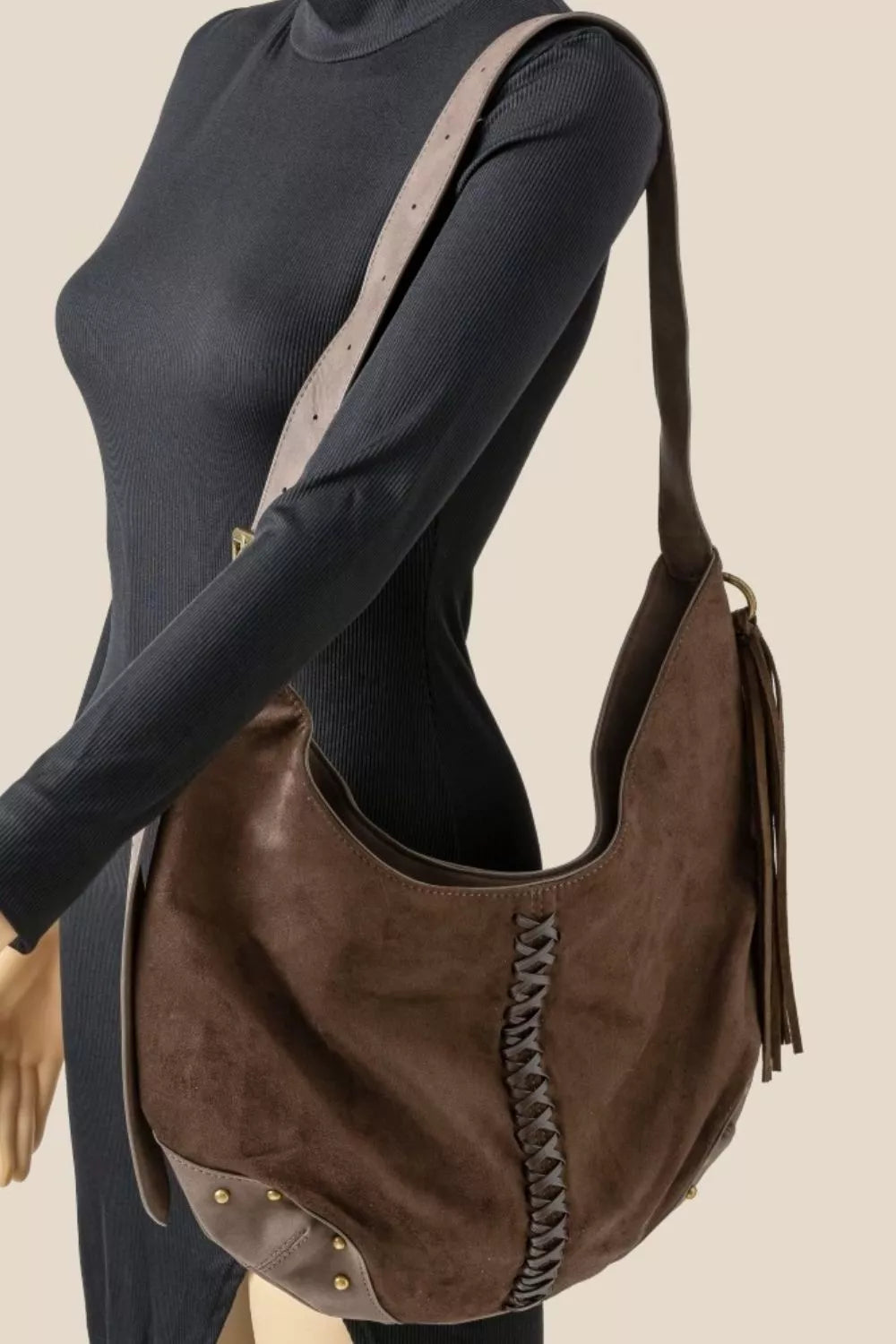 Brown suede hobo shoulder bag worn on shoulder with braided front and side tassels