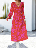 Hot pink floral V-neck long sleeve dress with cinched waist and tiered skirt, midi length