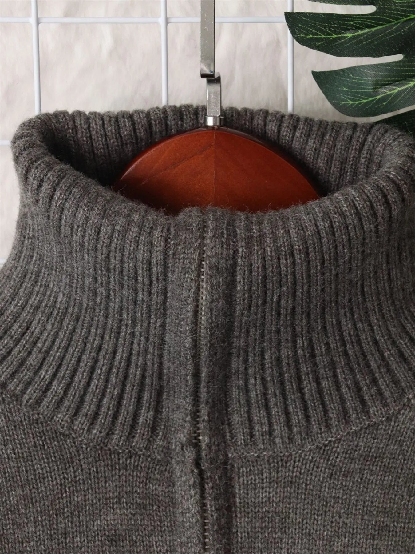 Gray half-zip sweater neckline with ribbed collar and metal zipper tab