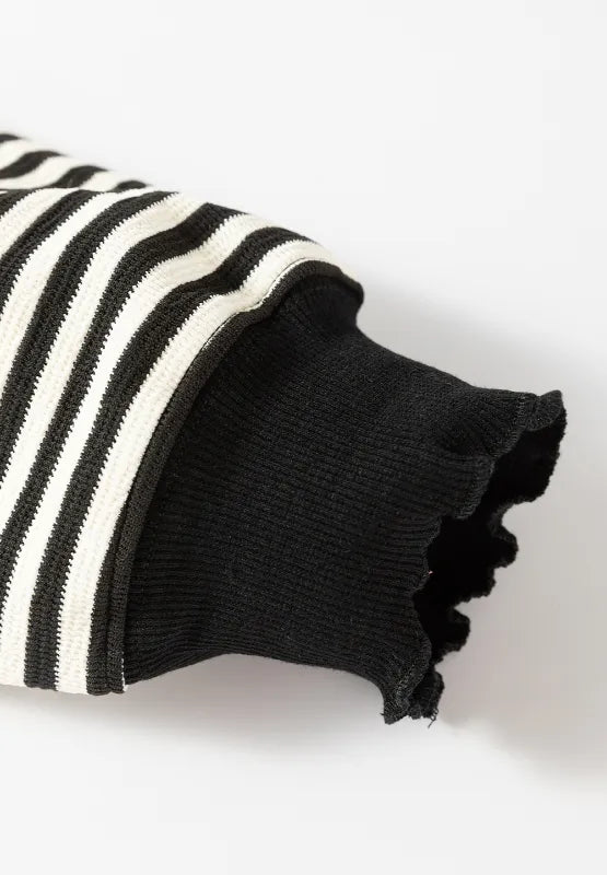 Striped sweatshirt sleeve cuff with ribbed black trim and black-and-white stripes