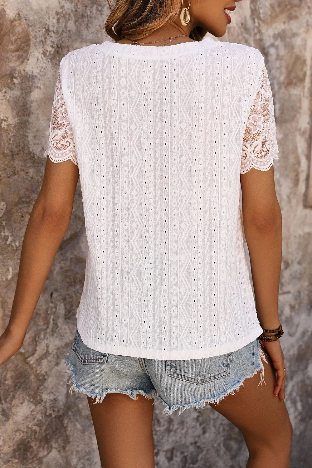 White eyelet short-sleeve T-shirt with round neck, viewed from the back
