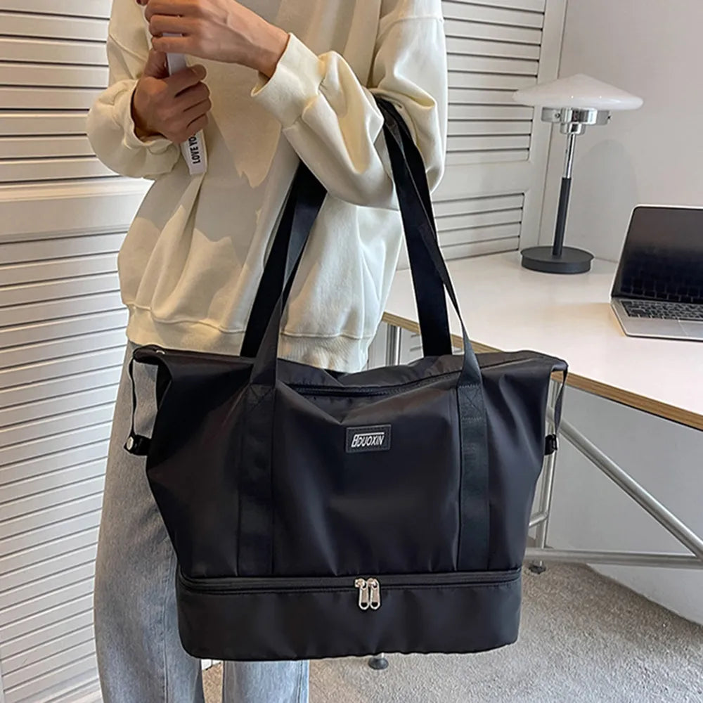 Black nylon duffel bag with front logo patch and top zipper closure