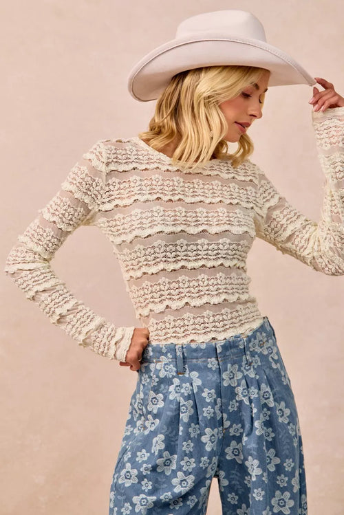 Cream lace ruffle top with layered stripe detailing and long sleeves, side view