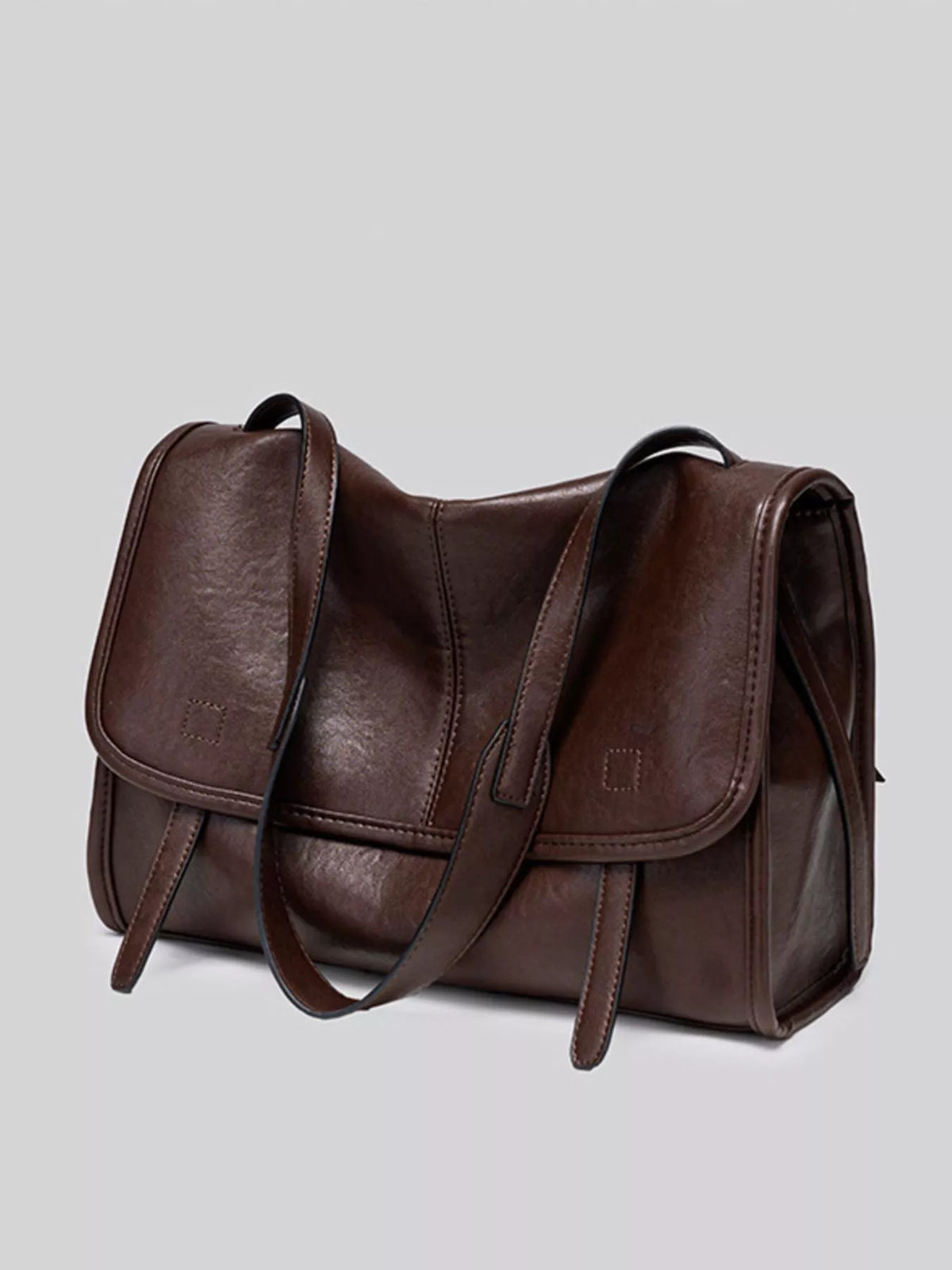 Brown vegan leather crossbody bag with flap front, side pockets, and twin handles