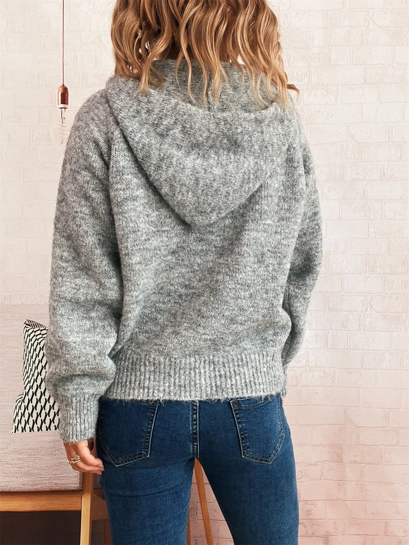 Dark gray quarter-zip sweater viewed from back with ribbed hem