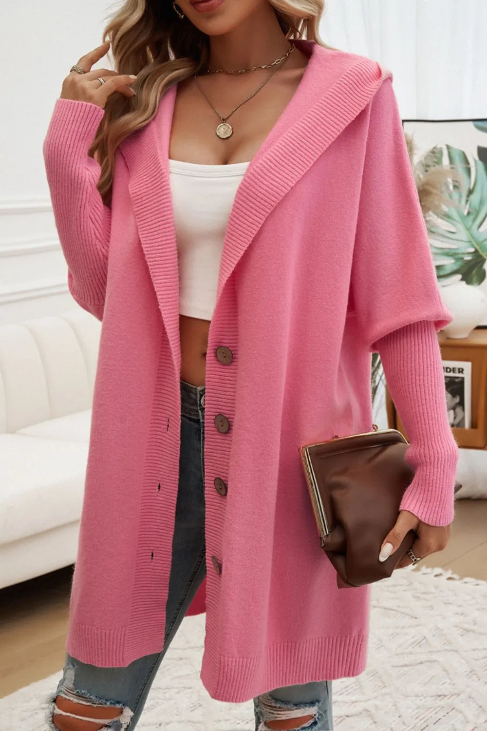 Pink hooded long cardigan with button front, ribbed knit, and long sleeves.