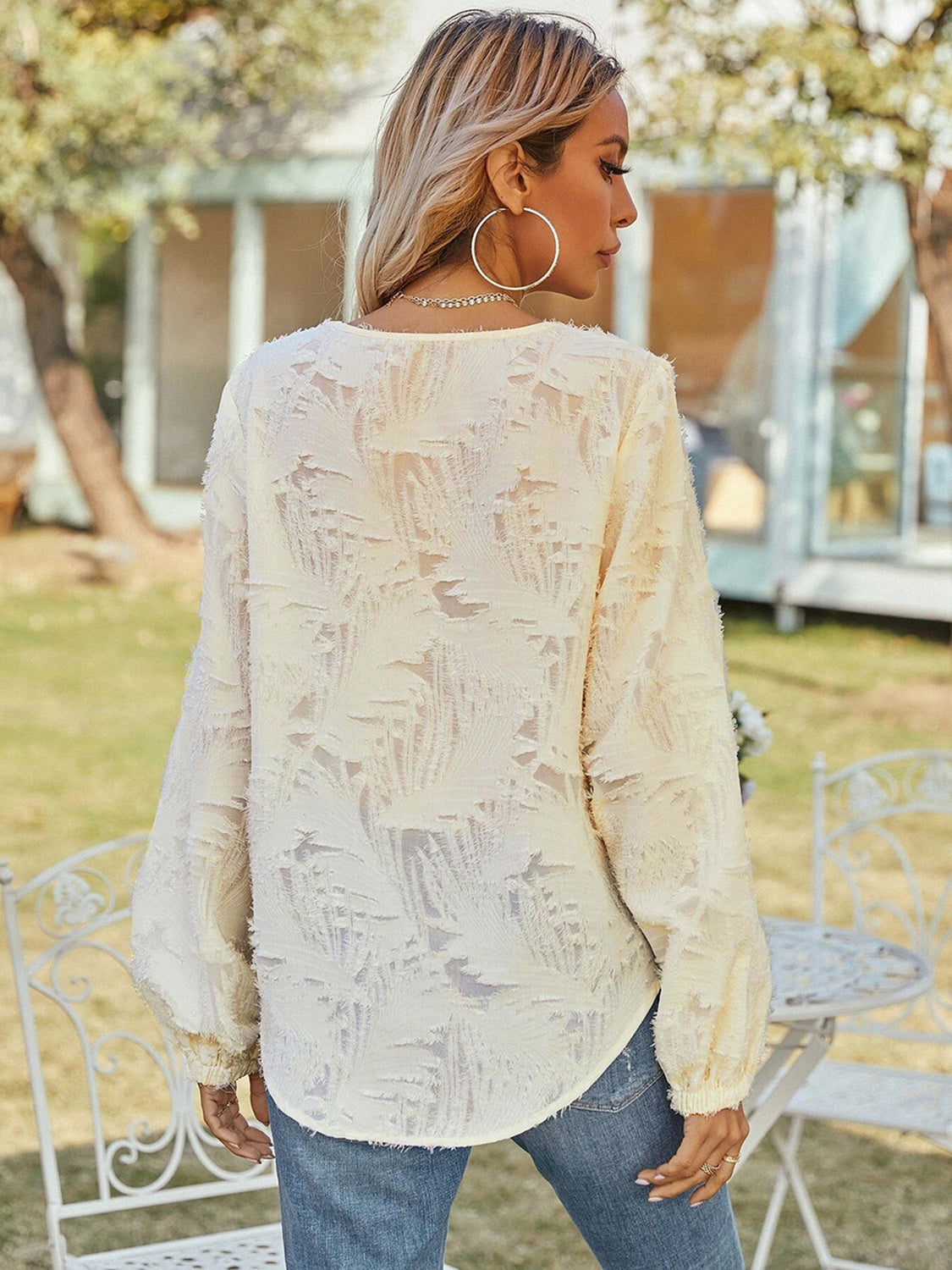 Cream V-neck long sleeve blouse with textured fabric and long sleeves, back view