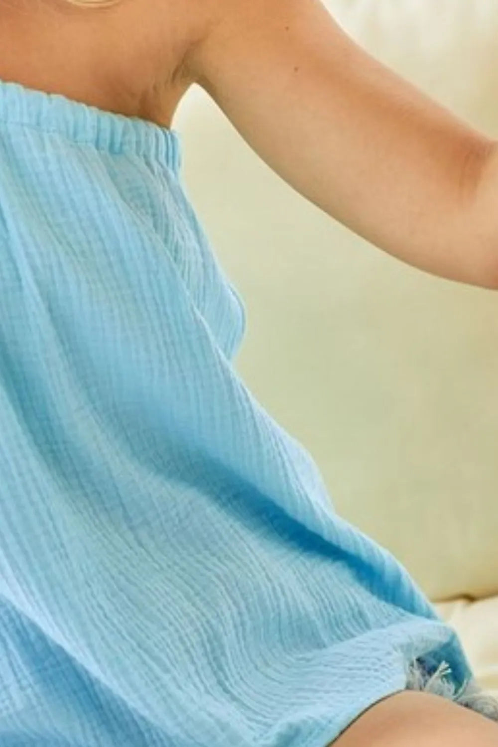 Light blue gauze off-shoulder top with textured weave and elasticized neckline