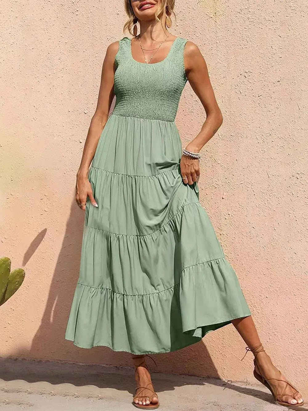 Light green tiered smocked wide-strap dress with sleeveless bodice and ruffled skirt tiers.