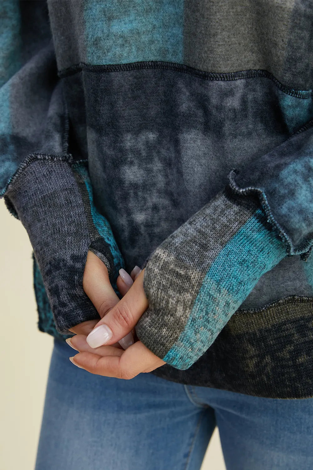 Plaid fleece hoodie sleeve and kangaroo pocket, dark gray with blue accents and cuff.