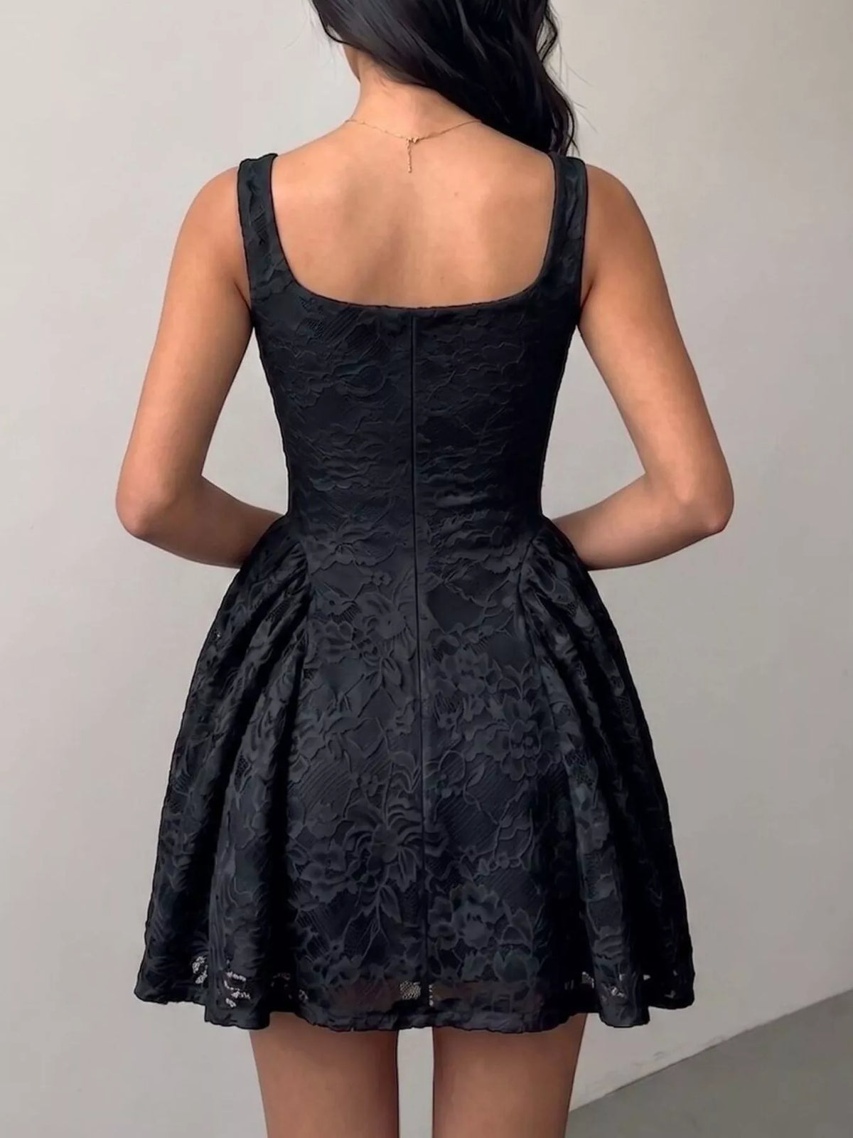 Black lace sleeveless dress with open back and floral textured fabric