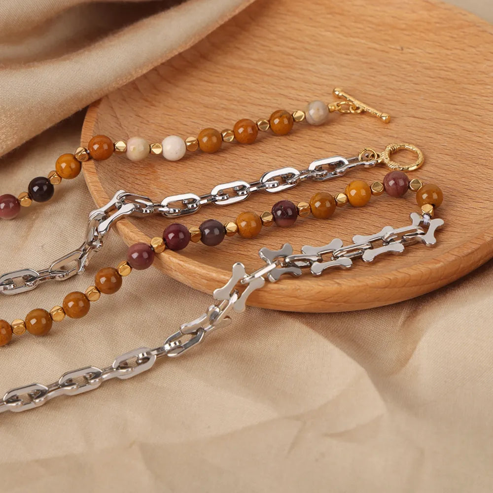 Beaded necklace with multicolor stone beads, silver-tone links, and a small gold charm