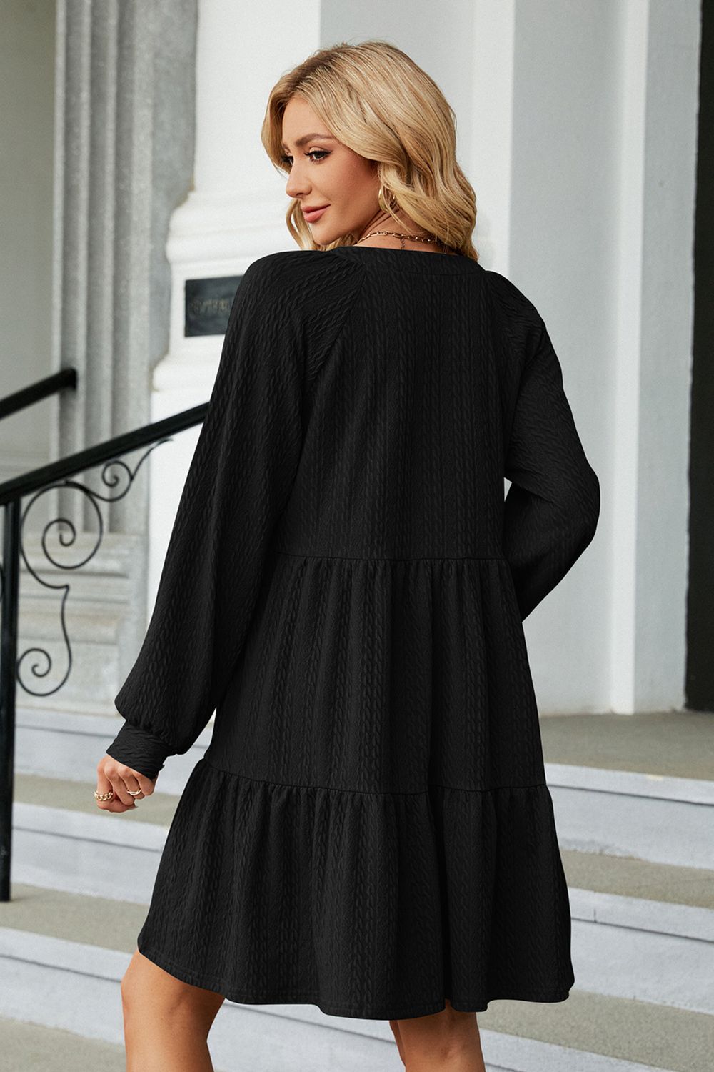 Black notched neck long sleeve mini dress, back view with tiered skirt