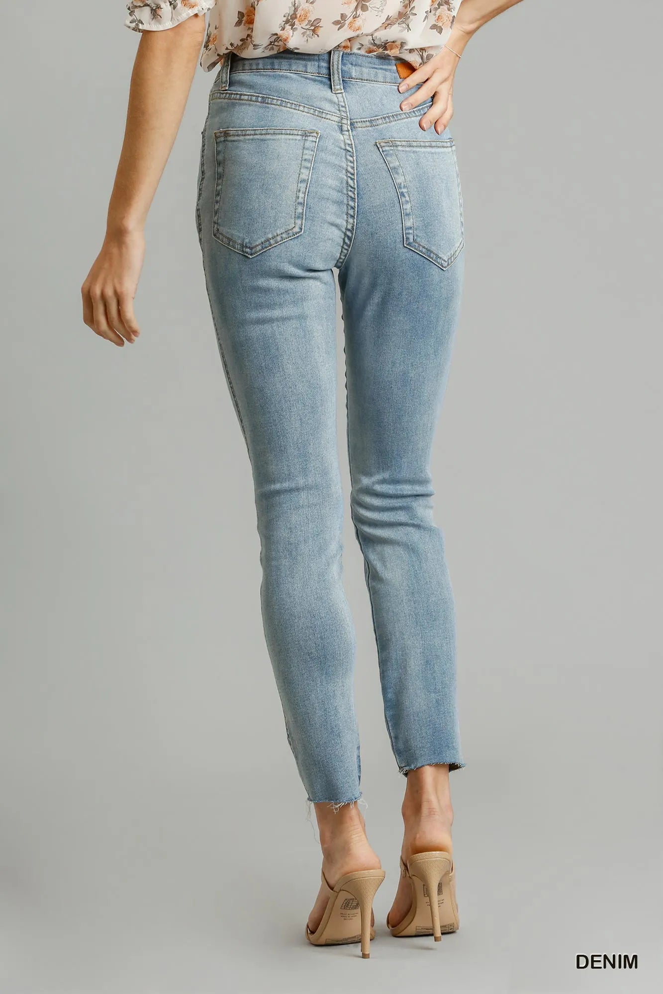 Light wash stretch skinny jeans with 5 pockets, front seams, ankle frayed hem