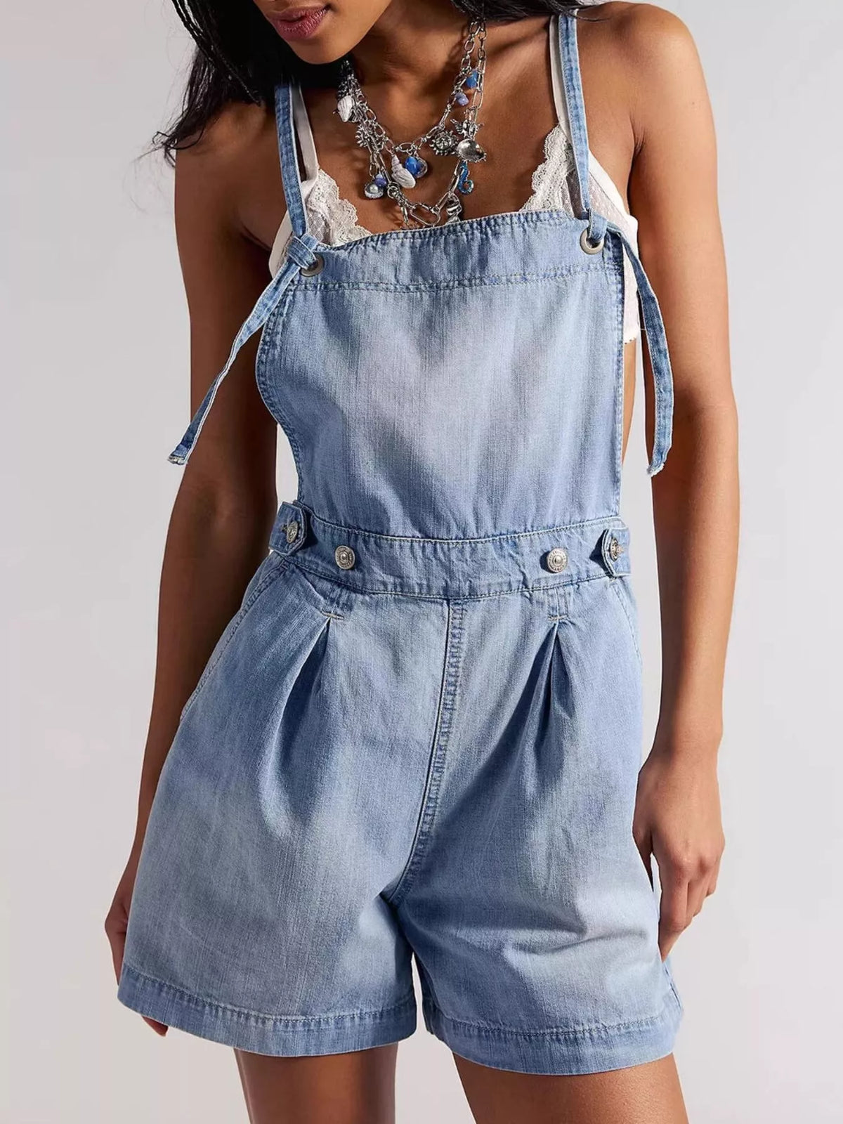 Light blue washed denim backless shorts overalls with pleated front and tie shoulder detail