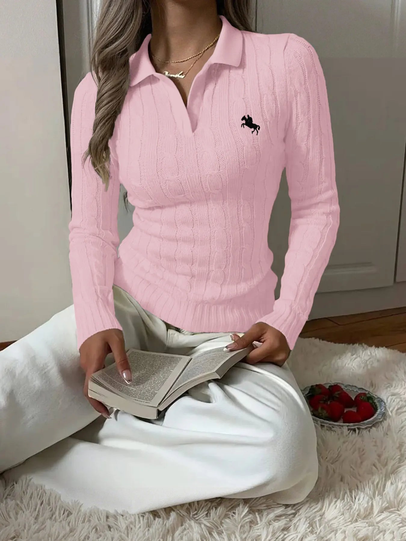 Pink cable-knit long-sleeve sweater with buttoned collared neckline and horse logo