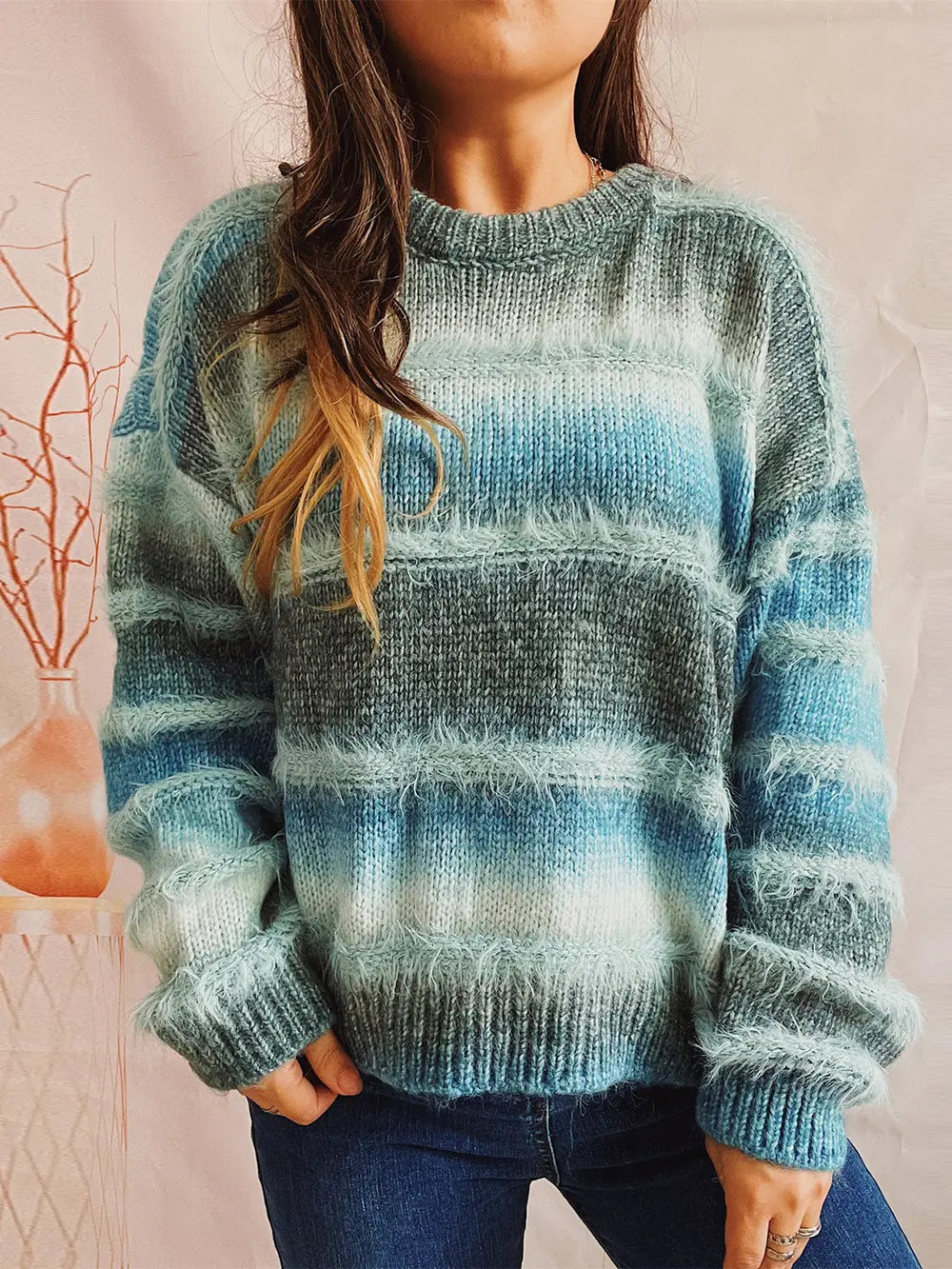 Blue and green striped round-neck long-sleeve sweater on model, ribbed cuffs