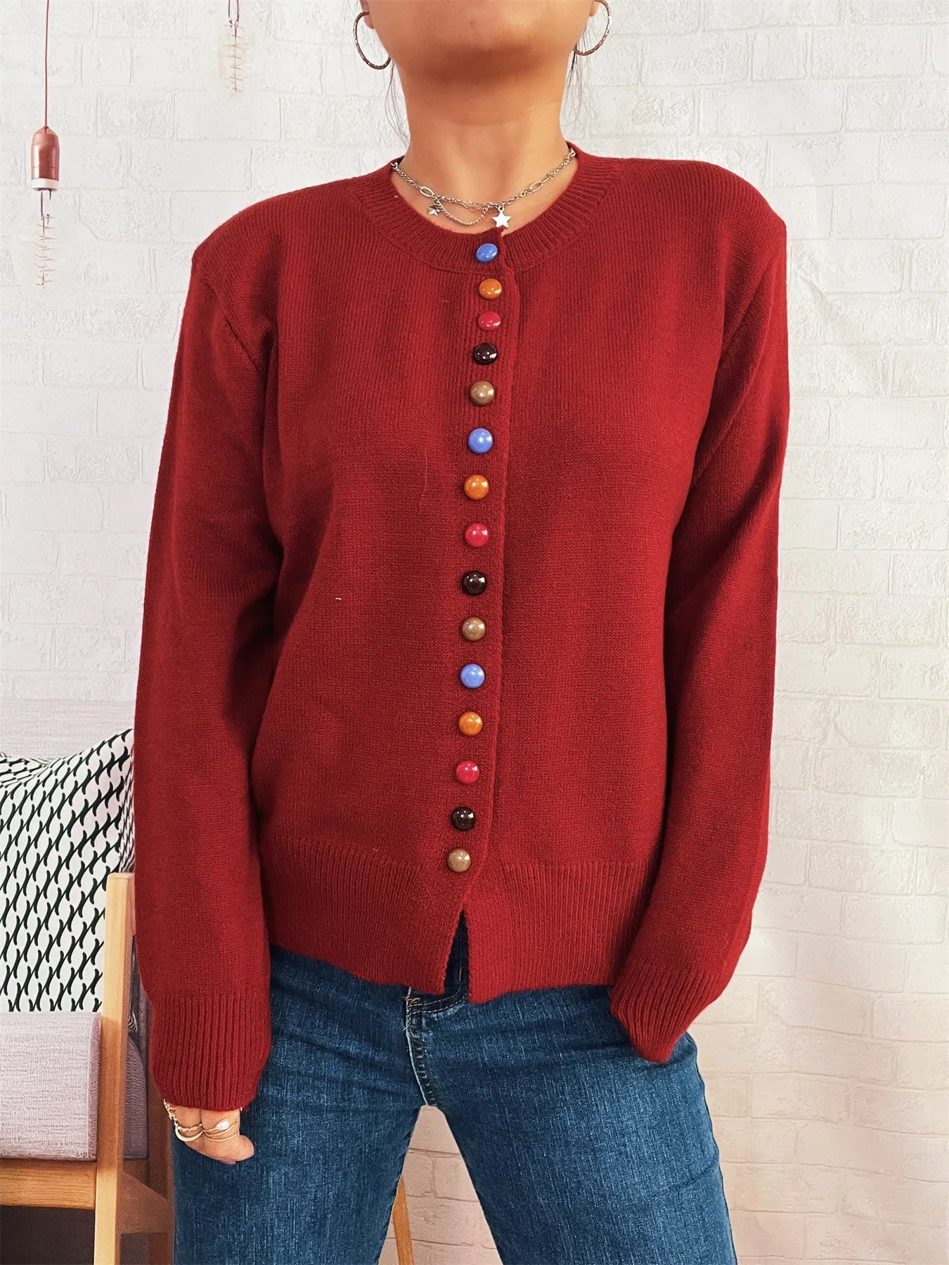 Red button-front cardigan with long sleeves and vertical row of colorful buttons