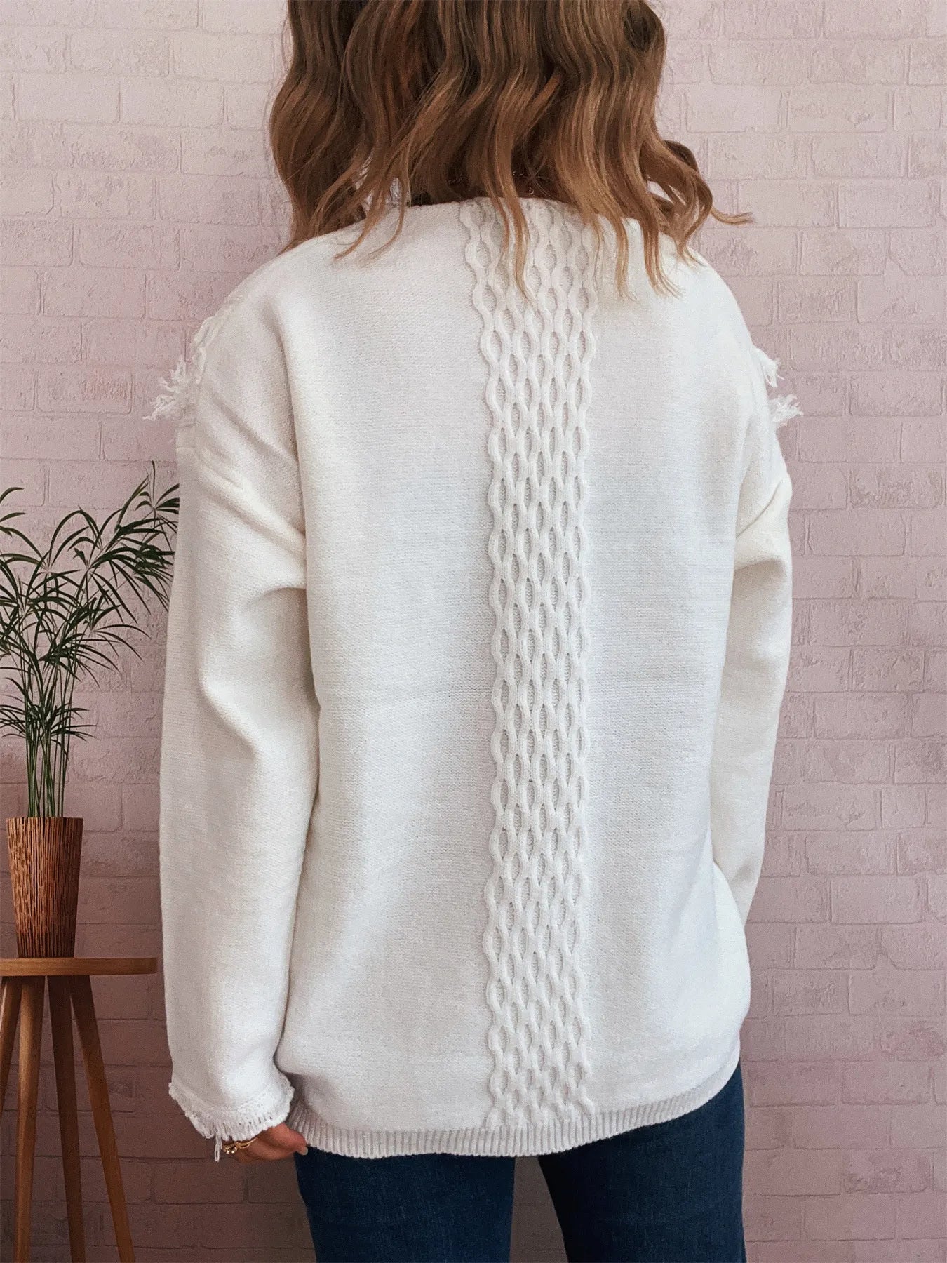 White cable knit back sweater with raw-hem finish and frayed sleeve edges